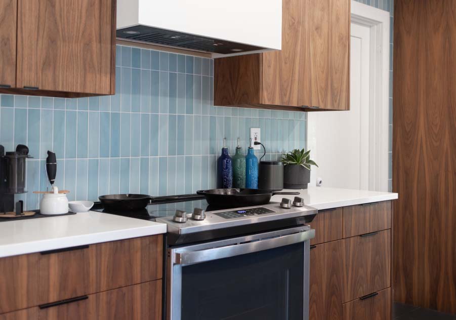 Modern kitchen design with warm wood cabinets and blue tile backsplash